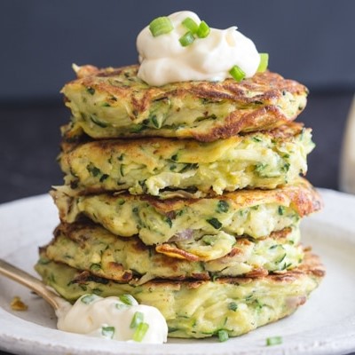 Zucchini patties stacked with sour cream on top
