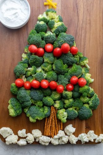 Veggie platter in shape of Christmas tree - broccoli & tomatoes, with yellow capsicum star and pretzel trunk