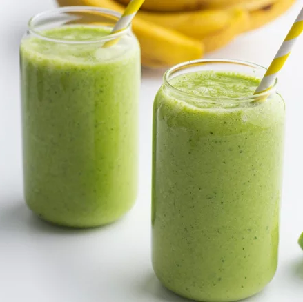 2 glasses with green smoothie and yellow paper straws